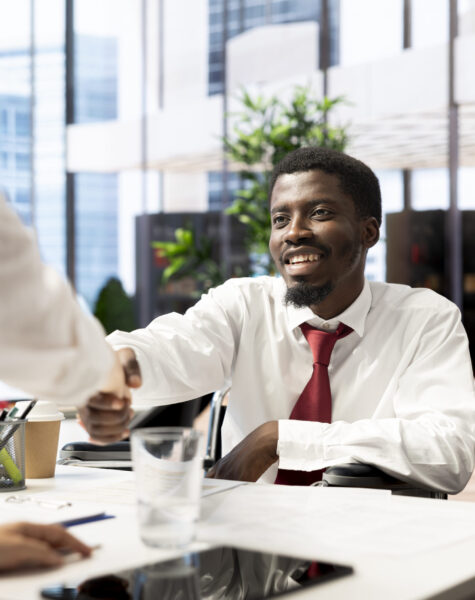 HR employee does greeting handshake with happy candidate in wheelchair after determining he possesses needed skills. HR manager shakes hands with cheerful person with disability after evaluation
